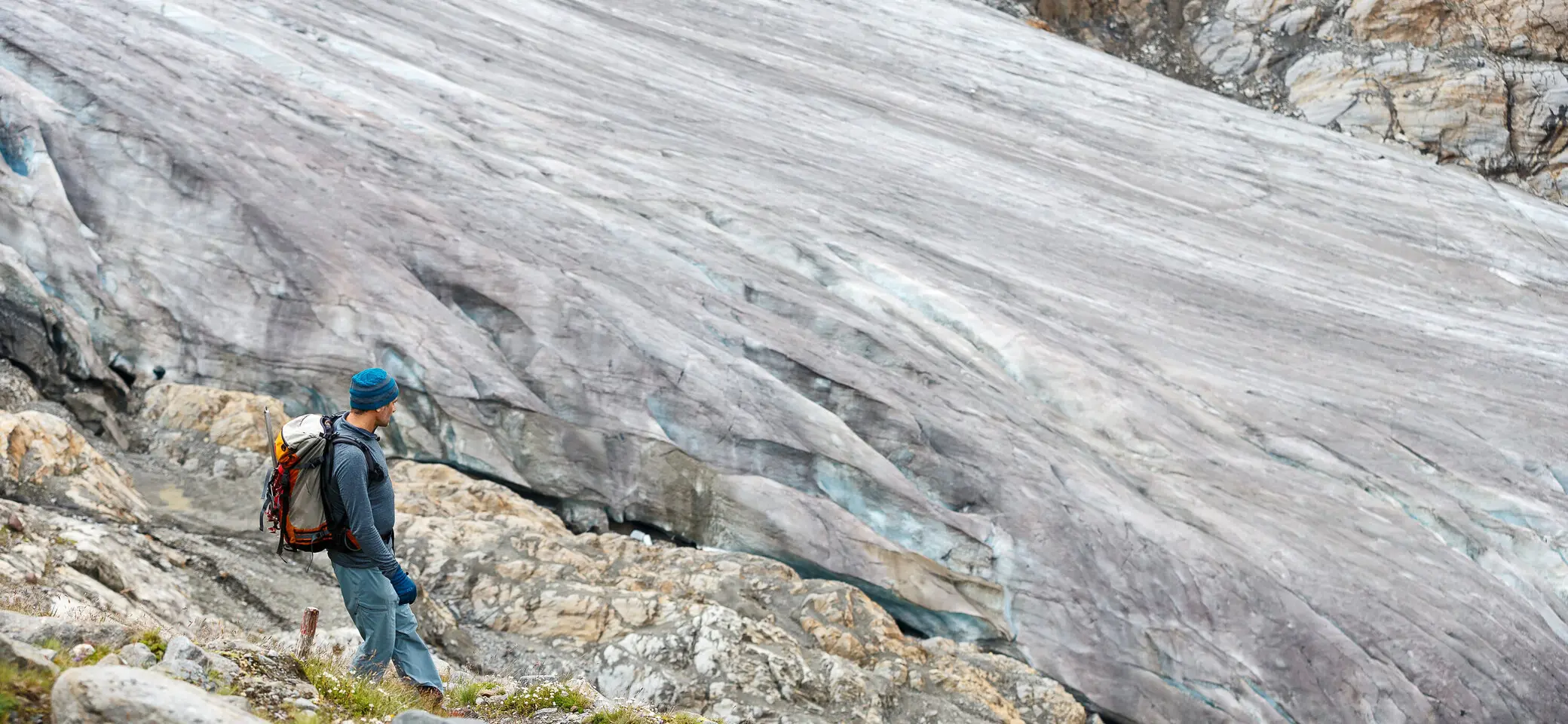 Ein Mann mit Rucksack wandert auf einem Gletscherfeld | © DAV/Marco Kost